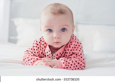 Cute baby on the white bed - Shutterstock ID 553738105