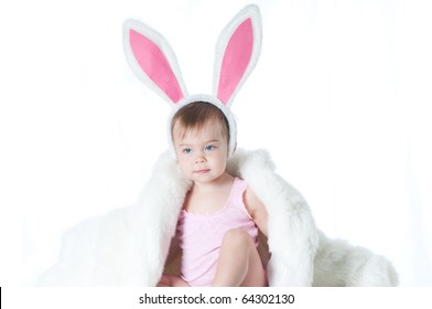 Cute Baby In A Pink Bunny Suit And A White Fur Coat Isolated On White