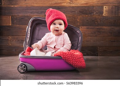 Cute Baby In Pink Travel Bag On Wooden Background