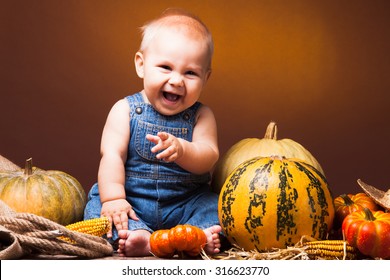 Cute Baby Posing On The Background Of Pumpkins. Thanksgiving Greetings