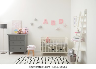 Cute baby room interior with crib and chest of drawers near white wall - Shutterstock ID 1815725066