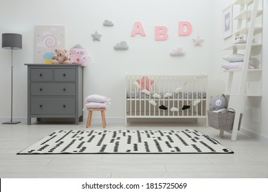 Cute baby room interior with crib and chest of drawers near white wall - Shutterstock ID 1815725069