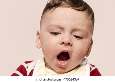 Cute Baby Screaming Refusing To Eat Baby Food. Sad Baby Throwing A Tantrum And Yelling With His Mouth Open. Six Month Old Beginning Food Diversification.