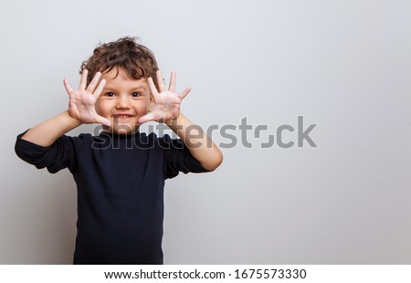 cute baby shows soaped hands to the camera. hygiene procedures. prevention of viral and bacterial diseases. Hand disinfection. studio photo isolated on white background