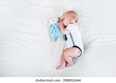 Cute Baby Sleeping On Bed Close-up And Copy Space. Child 6 Months Old, Colic, Teething.