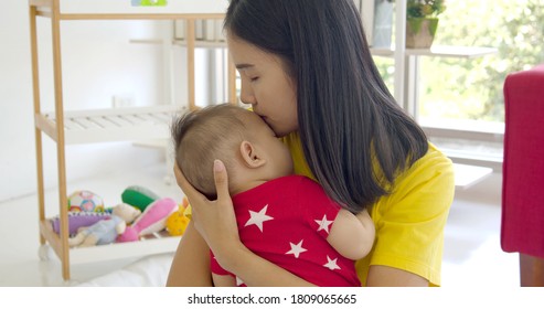 Cute Baby Sleeping On Mom Shoulder. Mother Hold Little Baby And Lulls Her Newborn Baby In Her Arms