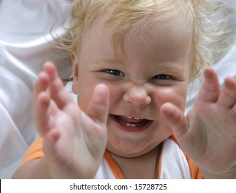 Cute Baby Smiling And Reaching Hands Toward Camera