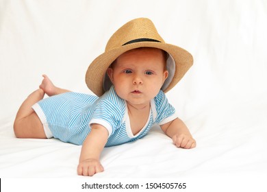 Cute Baby In A Striped Suit In A Big Sun Hat On A White Background.