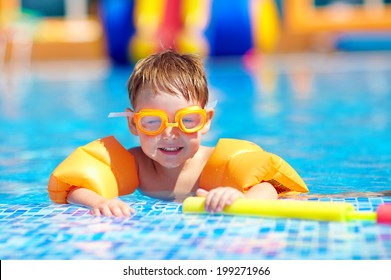 cute baby swimming in pool with inflatable arm rings