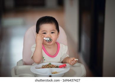 Cute Baby Try To Eating By Herself On The Baby Seat