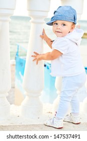 Cute Baby Trying To Walk Near The Column