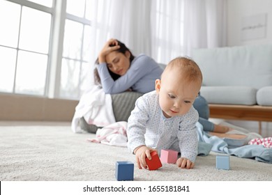 Cute Baby And Young Woman Suffering From Postnatal Depression At Home