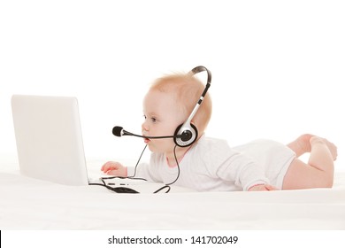 Cute baby-operator with laptop on the white bed