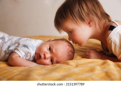 Cute bald chubby baby 2 months old and sister on bed in bedroom, baby siblings at home, toddler girl and baby in a cozy bedroom - Powered by Shutterstock