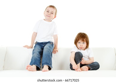 Cute Barefoot Preschool Boy And Girl On Sofa Or Couch, White Background.