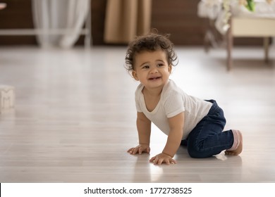 Cute barefoot toddler African American girl crawling on warm wooden floor with underfloor heating at home, pretty adorable baby little child learning to walk, first steps on hands and knees - Powered by Shutterstock