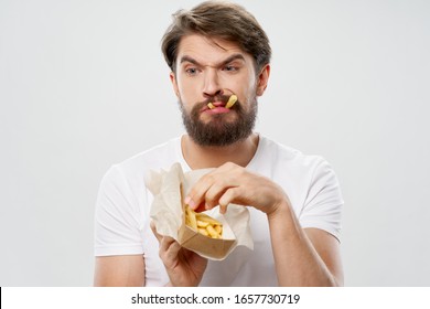 Cute bearded man eating a french fries diet