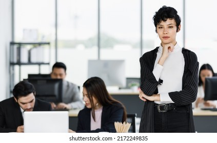 Cute and beautiful businesswoman in suit dress standing in the office and touc her chin with self-confident and elegant pose.
