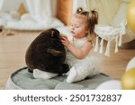 Cute beautiful girl baby sitting on the floor in the children