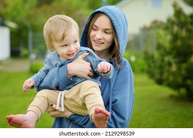 Cute Big Sister Cuddling With Her Toddler Brother. Adorable Teenage Girl Holding Baby Boy. Children With Large Age Gap. Big Age Difference Between Siblings. Big Family.