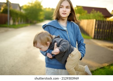 Cute Big Sister Cuddling With Her Toddler Brother. Adorable Teenage Girl Holding Baby Boy. Children With Large Age Gap. Big Age Difference Between Siblings. Big Family.