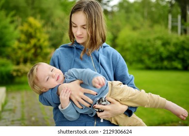 Cute Big Sister Cuddling With Her Toddler Brother. Adorable Teenage Girl Holding Baby Boy. Children With Large Age Gap. Big Age Difference Between Siblings. Big Family.