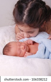 Cute Big Sister Looking Over Brand New Newborn Baby Brother