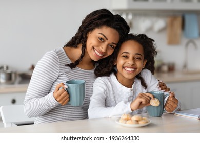 Cute Black Mother And Daughter Drinking Tea With Cookies