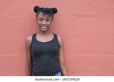 Cute black Pre teen girl outdoors sunny summer day burnt orange wall background