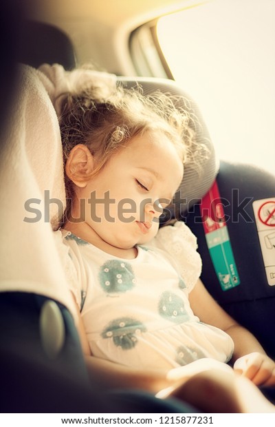 Cute blond baby sleeping in baby car seat.\
Safety Concept.