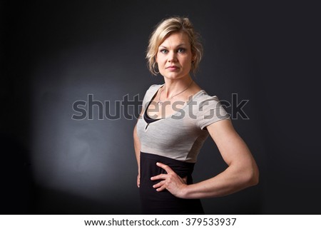 Similar – Close up front upper body portrait of one young athletic woman in sportswear in gym over dark background, looking at camera