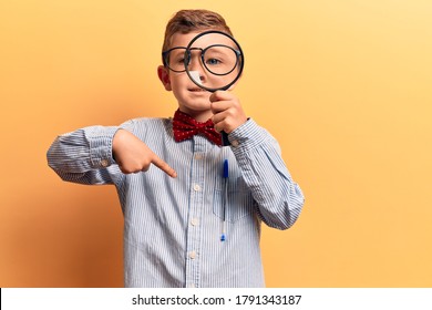 Cute Blond Kid Wearing Nerd Bow Tie And Glasses Holding Magnifying Glass Pointing Finger To One Self Smiling Happy And Proud 