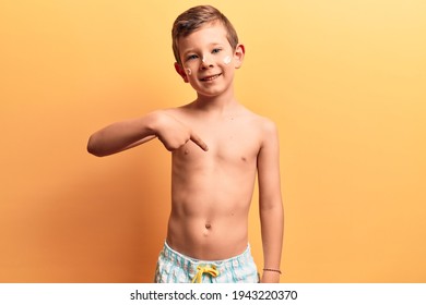 Cute Blond Kid Wearing Swimwear Pointing Finger To One Self Smiling Happy And Proud 