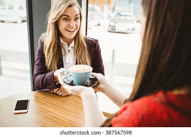 Cute blonde Girl, die von ihrem Freund in einem Café Kaffee serviert hat