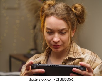 A Cute Blonde Girl Is Playing A Video Game On A Tablet In The Room. Close-up. Leisure, Video Games, Communications, Youth Culture, Game Strategy.