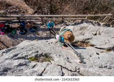 Cute Blonde Girl Rock Climbing Using Top Rope With Her Mother Protecting Her.