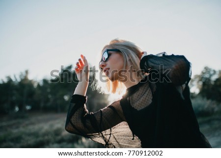 Similar – Blonde junge Frau mit Hut und Sonnenbrille, die bei Sonnenuntergang im Wald mit einem Mobiltelefon ein Foto macht.