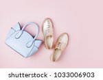 Cute blue ladies bag and stylish golden shoes. Flat lay, top view. Spring fashion concept in pastel colored