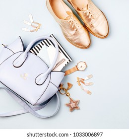 Cute blue ladies bag, stylish golden shoes and  feminine accessories . Flat lay, top view. Spring fashion concept in pastel colored  - Shutterstock ID 1033006897