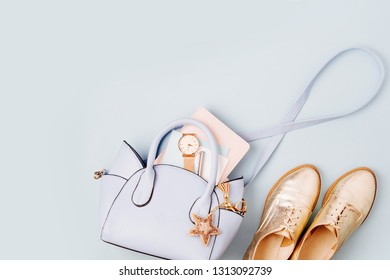 Cute blue ladies bag, stylish golden shoes and  feminine accessories . Flat lay, top view. Spring fashion concept in pastel colored  - Shutterstock ID 1313092739