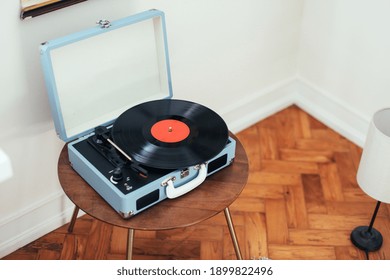 A Cute Blue Record Player On A Wooden Table In A Corner Of A Bright Room With White Walls