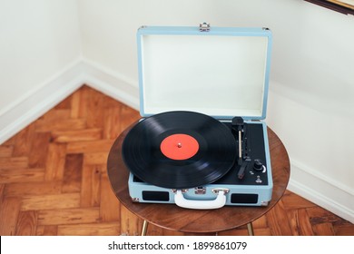 A Cute Blue Record Player On A Wooden Table In A Corner Of A Bright Room With White Walls