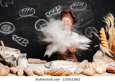 Cute Boy In Apron And Hat Throwing Flour Powder In Air With Eyes Closed Having Fun While Making Dough.