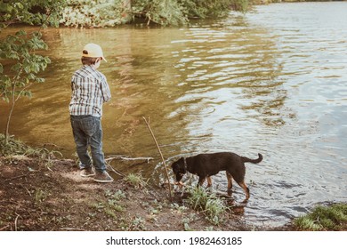 Cute Boy And Dog Play Near A River Or Lake. Growing Up, Love For Animals - Dogs, Free Time, Travel, Vacation