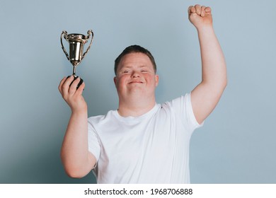 Cute boy with down syndrome holding a trophy