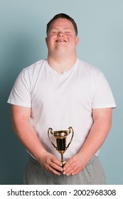 Cute Boy With Down Syndrome Holding A Trophy