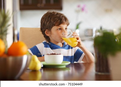 Cute boy drinking orange juice and eating muesli for breakfast - Powered by Shutterstock