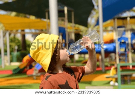 A cute  boy drinks water from plastic bottle. Summer thirst, preschooler drinking water on a hot day