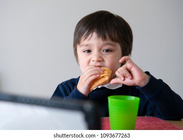 Cute Boy Eating Fresh Tortilla Wraps With Chicken, Bacon And Mixed Vegetables While Watching Cartoons On Tablet, Cute School Kid Eating Mexican Sandwich Food For His Lunch, Healthy Food For Kids