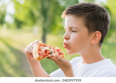 Cute boy eating pizza outdoors in summer - Powered by Shutterstock